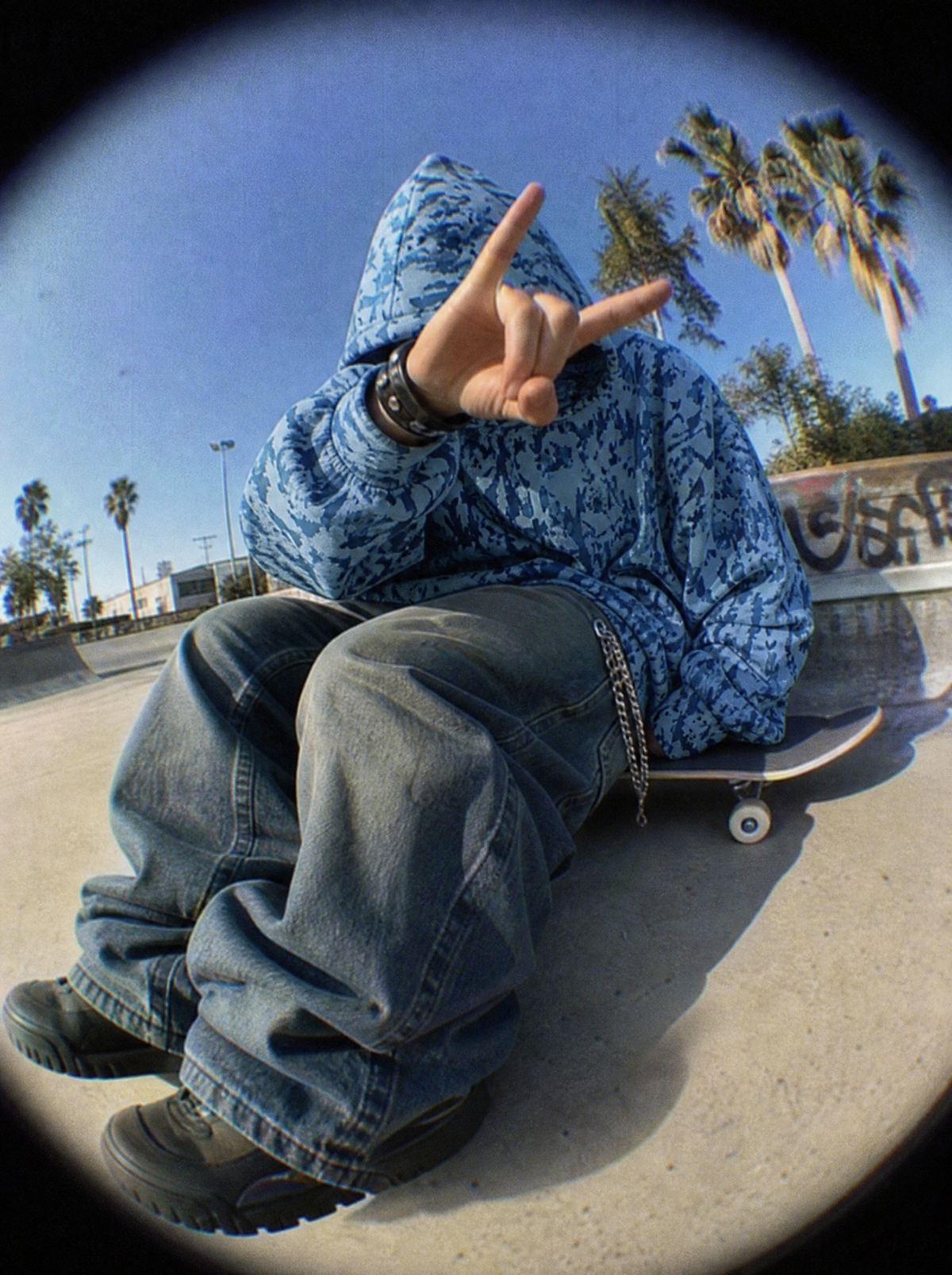 Skull Camo Hoodie styled Y2K, fisheye skatepark shot