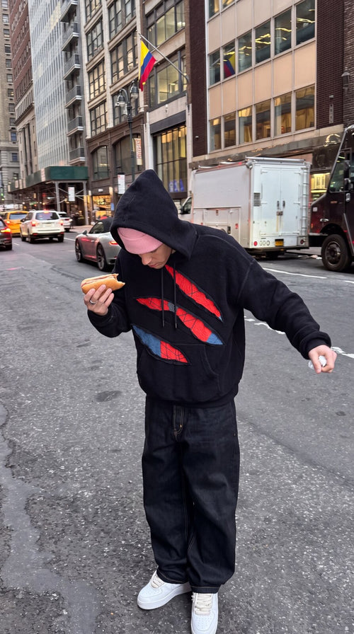 SpideyComfort distressed spider-web hoodie worn on a NYC street